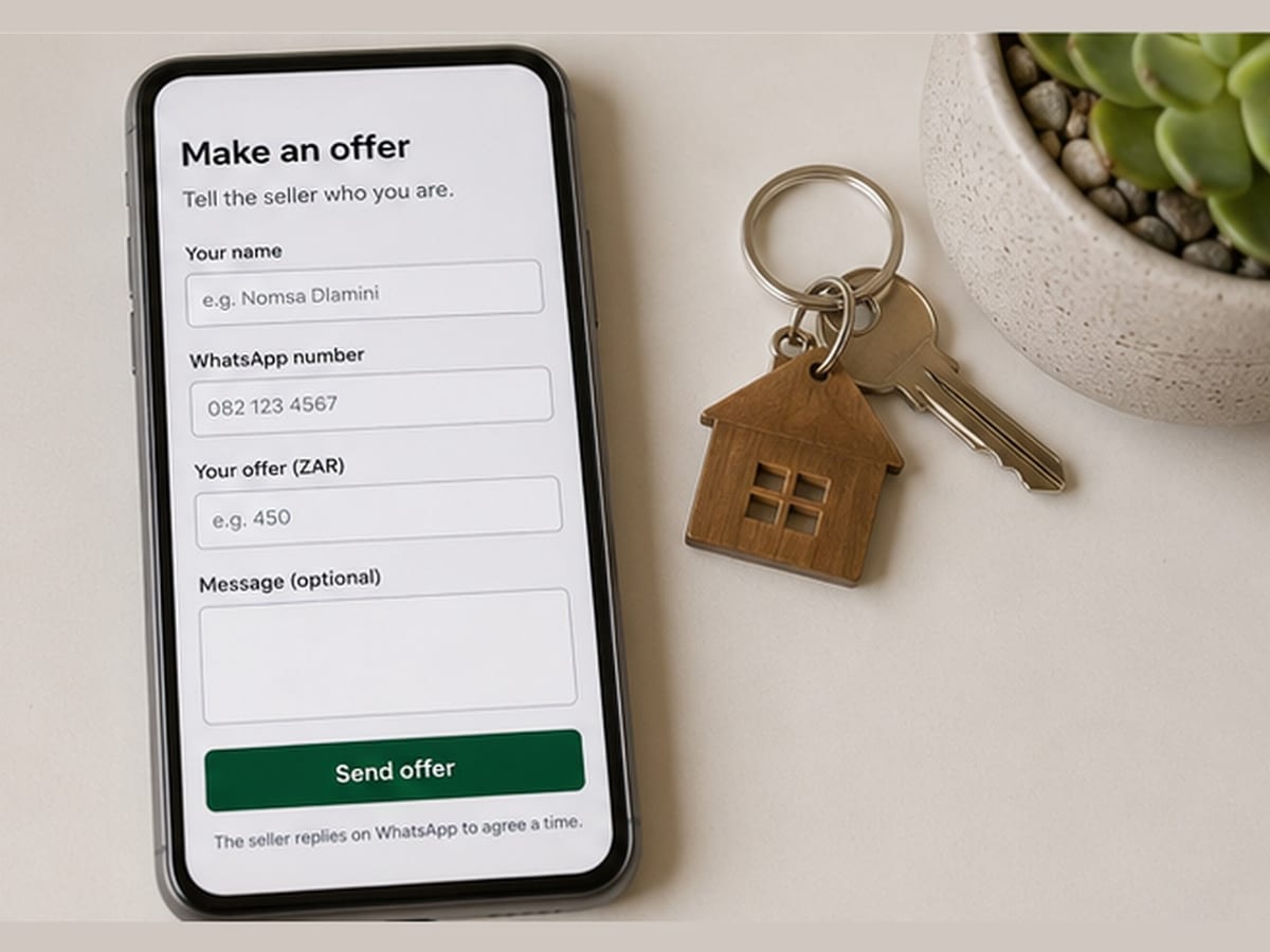 Phone showing the Make an offer form beside keys on a wooden house keyring.
